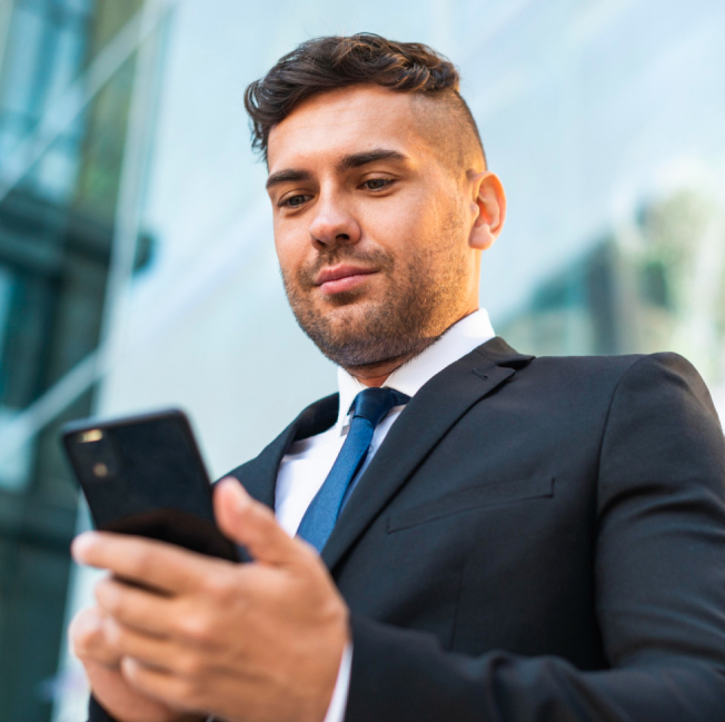 A businessman in a suit using a smartphone.