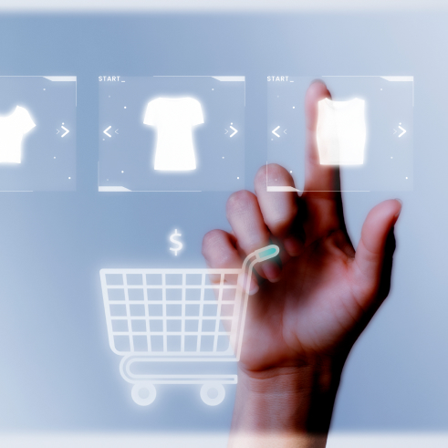 Una mano interactuando con una interfaz de compras virtual futurista con íconos para la selección de ropa y un carrito de compras.