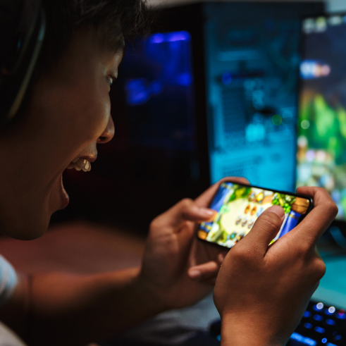Person playing a mobile game with intense focus.