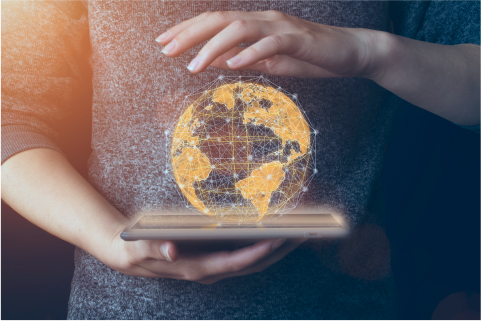 Une personne tient une tablette projetant une image holographique d’un globe numérique avec un symbole monétaire.