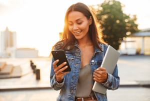 a woman holding a laptop and a phone